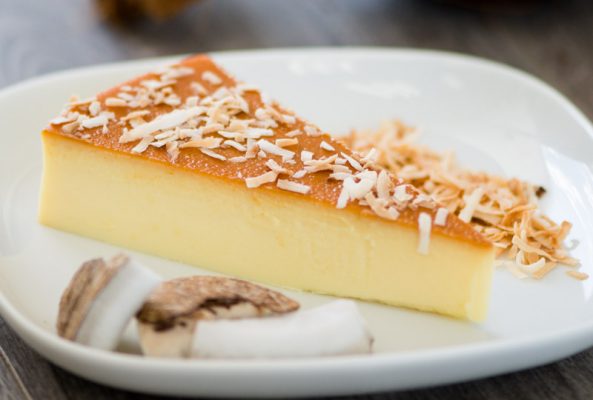 Flakes of coconut on a slice of coconut flan Flakes of coconut on a slice of coconut flan