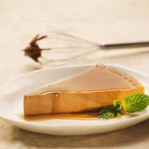 Slice of Dulce de Leche Flan and a mint leaf on a plate Slice of Dulce de Leche Flan and a mint leaf on a plate