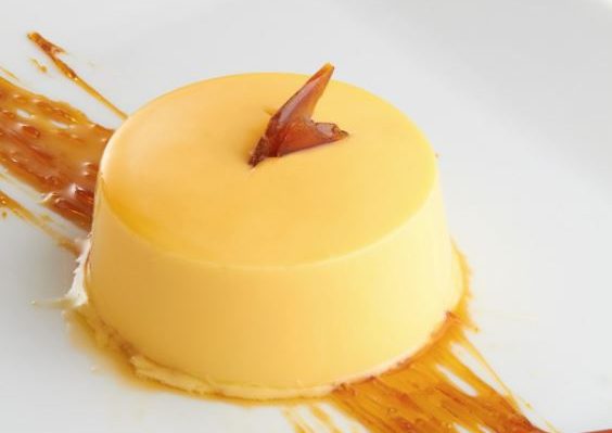 A small round piece of white chocolate leche flan